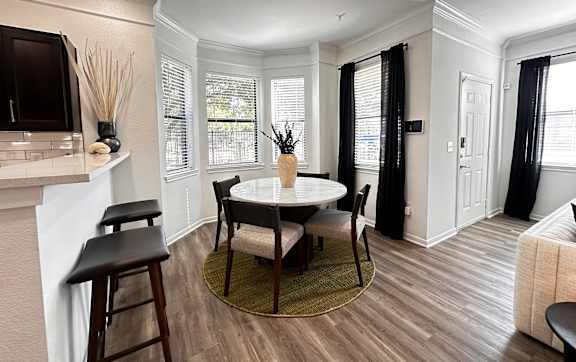 an open living room with a couch and a door to a balcony at Grand Villas Apartments, Katy