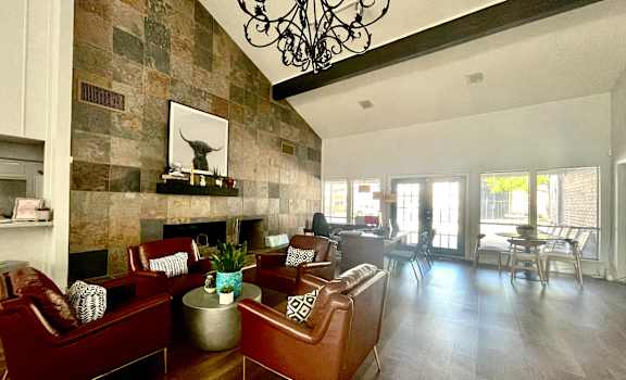 a living room with leather furniture and a stone wall