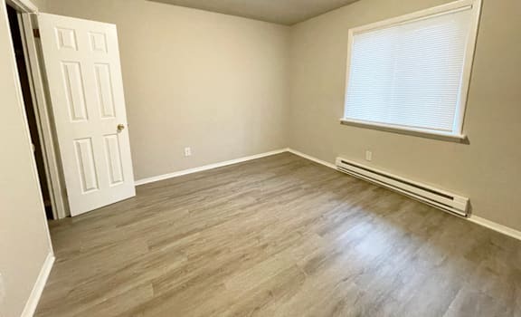 A room with a door, window, and radiator.
