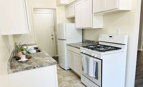 a kitchen with white appliances and white cabinets