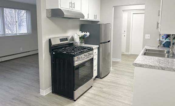 a kitchen with a stove and a refrigerator and a sink