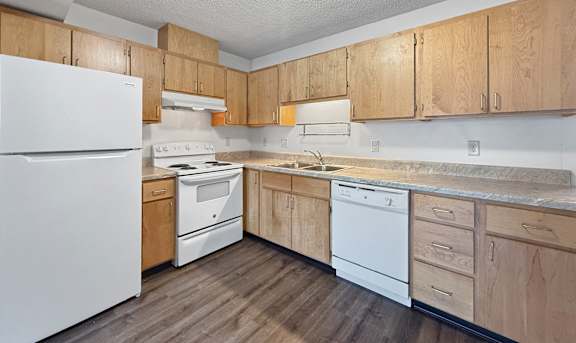 A kitchen with wooden cabinets and white appliances.
