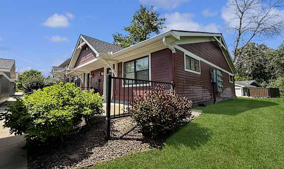 A house with a red siding and a black fence.