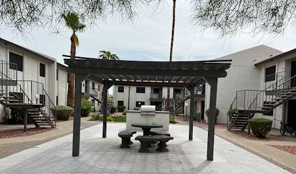 A patio with a table and chairs under a pergola.