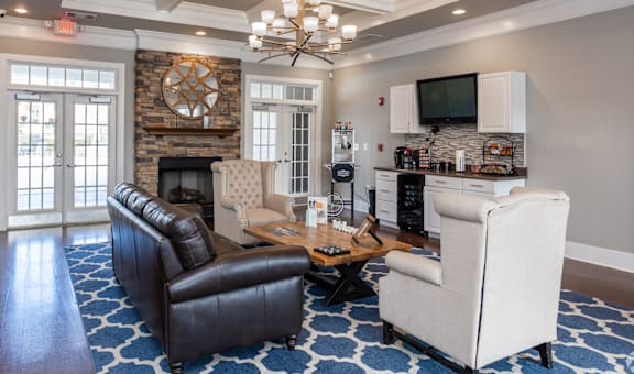 A living room with a black leather couch, a white armchair, and a wooden coffee table.