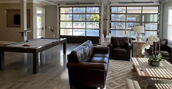 a living room with a pool table and couches