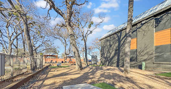 A concrete block with a hole in the middle is in the foreground of a grassy area.