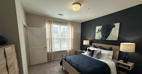 a master bedroom with a large bed and a black accent wall