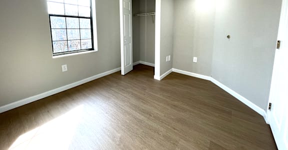 A room with a window and a door leading to another room.