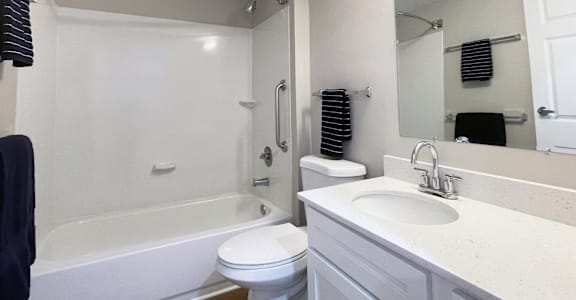 A white bathroom with a toilet, sink, and bathtub.