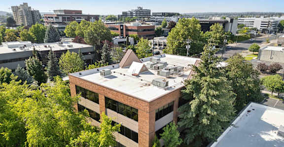 an aerial view of a building with a city in the background