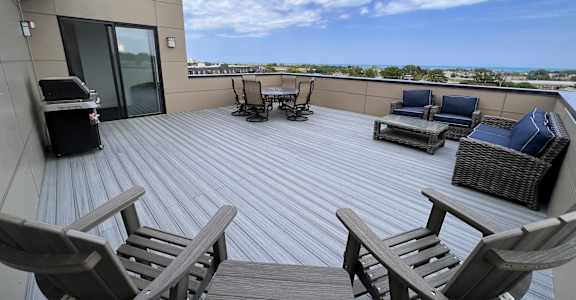 a patio with chairs and a grill on a roof