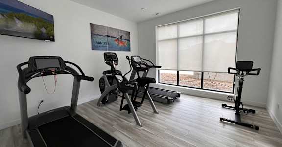 a gym with exercise equipment in a room with a window