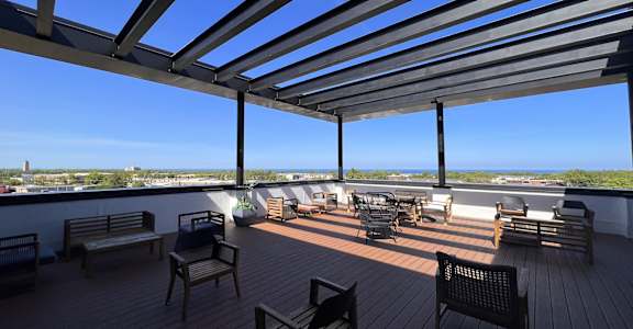 the deck at the top of a building with tables and chairs