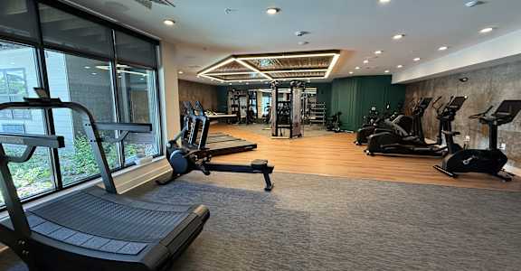 A spacious gym with treadmills, elliptical machines, and other exercise equipment.