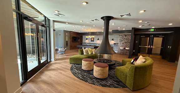 A modern living room with a green armchair and a black floor lamp.