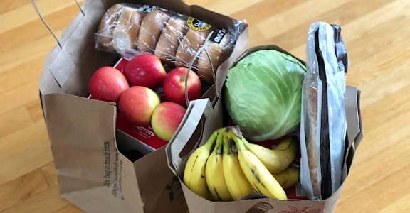 a box of fruit and vegetables on a wooden floor