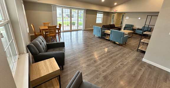 an open living room with couches and chairs and a dining room with a table