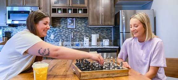 women playing chess at a table