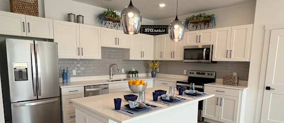 a large kitchen with white cabinets and stainless steel appliances