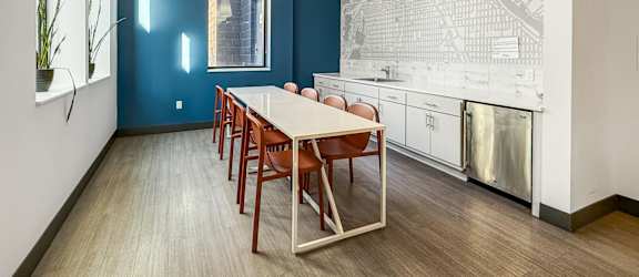 A dining room with a long table and chairs.