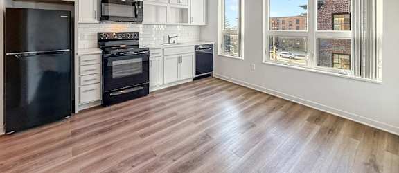 A kitchen with black appliances and white cabinets.