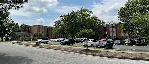 a parking lot in front of a building with cars parked on the street