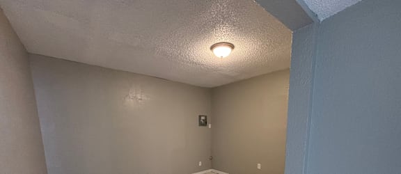 A room with a ceiling fan and a small window.