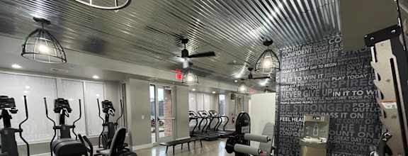 a workout room with weights and chairs and a chalkboard wall in a gym at Edge 35, Indianapolis, Indiana