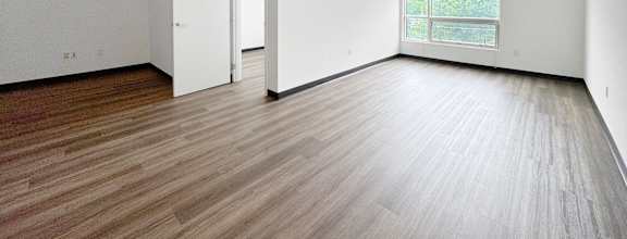 A room with wooden flooring and white walls.