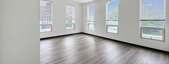A large empty room with wooden floors and white walls.