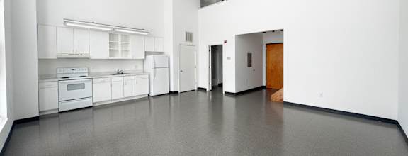 A spacious kitchen with white cabinets and appliances.