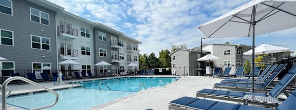 our apartments have a large pool with lounge chairs and umbrellas at Emery Village, Concord, NC