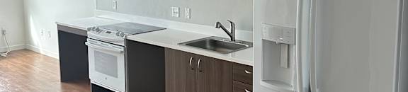 A white fridge is on the top of a kitchen counter.