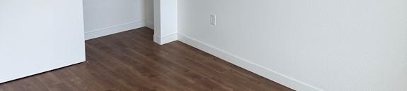 A white door is open in a room with a wooden floor.