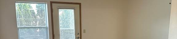 A room with a ceiling fan and a window.