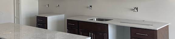 A white cabinet with drawers is on the left and a brown counter is on the right.