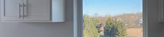 A white cabinet with a window above it.