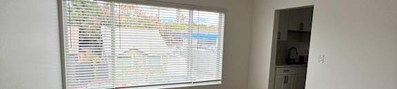 A room with a window and a wooden wall.