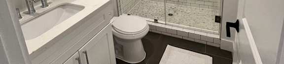 A bathroom with a white toilet and a glass shower stall.