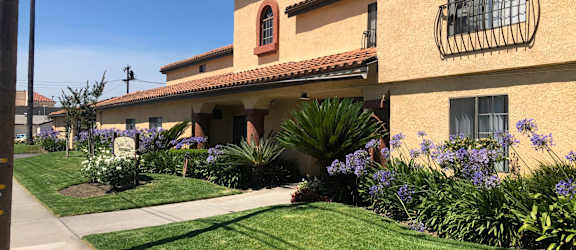 a house with a lawn and flowers in front of it