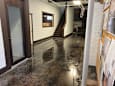 A hallway with a wet floor and a staircase.