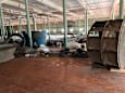 A large industrial room with a lot of clutter and a large fan.
