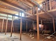 A large, unfinished room with exposed wooden beams and brick walls.