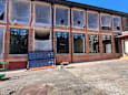 A building under construction with a blue panel in front.