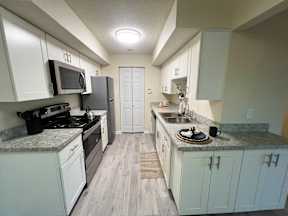 A kitchen with white cabinets and a granite countertop.