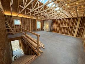 A room under construction with wooden beams and a concrete floor.