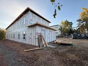 A house under construction with insulation on the walls.