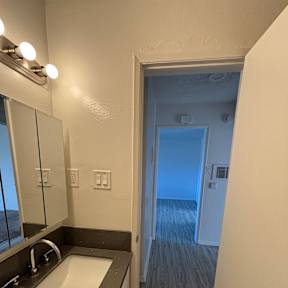 A bathroom with a sink, mirror, and a window.