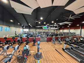 A gym with a variety of exercise equipment including treadmills, stationary bikes, and weight machines at Ironwood Apartments, Coeur d'Alene, Idaho